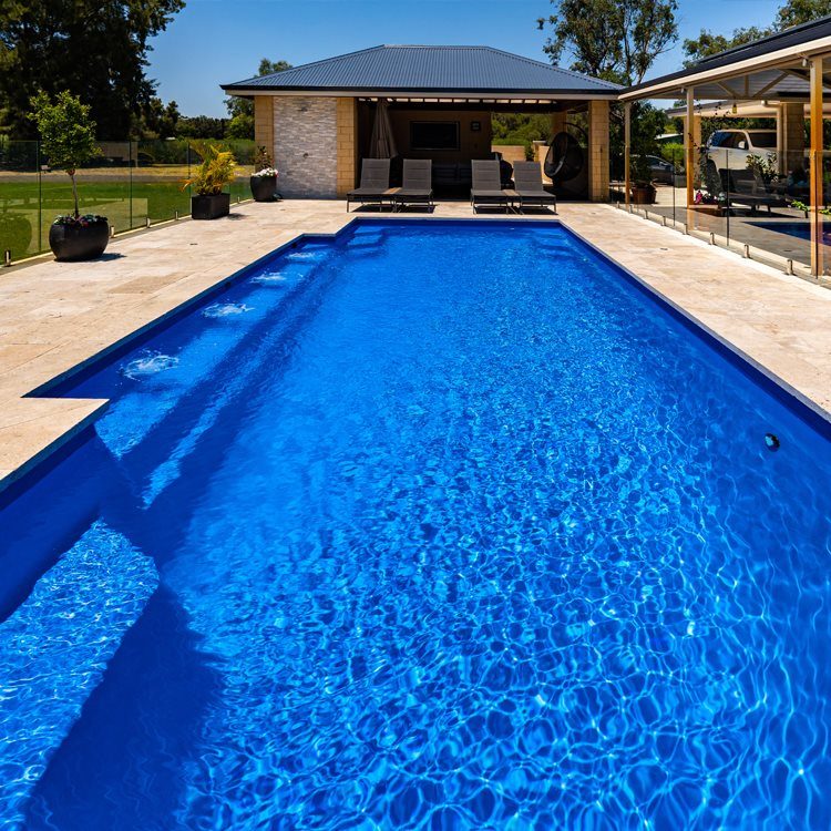 Long rectangular fibreglass family pool leading up to a covered outdoor room