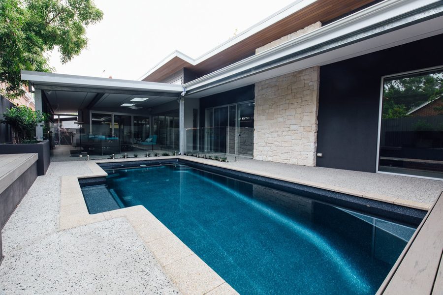 Dark-finish fibreglass pool beside a modern home