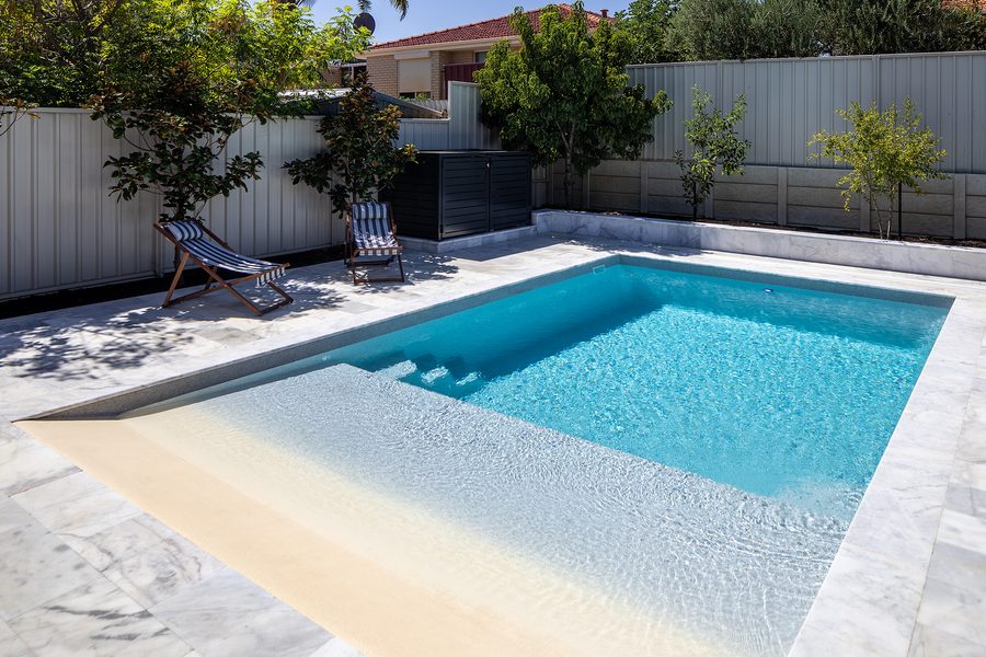 Fibreglass pool with a wide shallow lounging ledge and entry steps